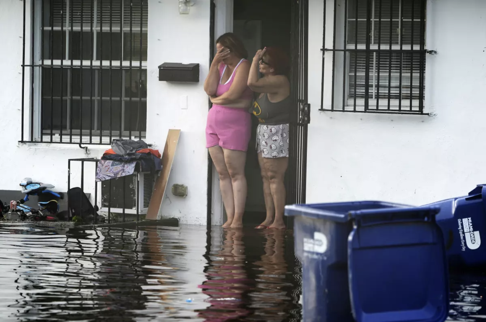 Image of residents surveying a flooded street in North Miami, courtesy of LA Times.